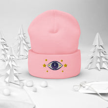 Load image into Gallery viewer, cuffed beanie baby pink, with image design of purple eye of protection/evil eye, with yellow stars. background: winter themed, Christmas gifts.
