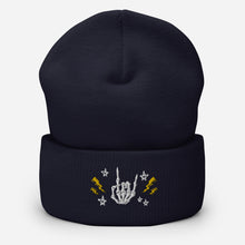 Load image into Gallery viewer, cuffed beanie navy blue, with image design of rock on skeleton hand, pentagram stars, lightning symbols. background: winter themed, Christmas gifts.