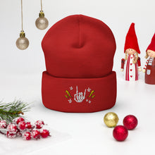 Load image into Gallery viewer, cuffed beanie red, with image design of rock on skeleton hand, pentagram stars, lightning symbols. background: winter themed, Christmas gifts.