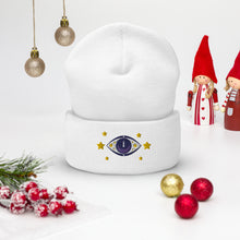Load image into Gallery viewer, cuffed beanie white, with image design of purple eye of protection/evil eye, with yellow stars. background: winter themed, Christmas gifts.