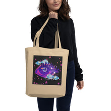 Load image into Gallery viewer, woman holding/modeling oyster beige tote bag, certified organic, tote bag, dreamy eye with a crescent moon in the iris, surrounded by soft, whimsical clouds, pink and purple stars, orange highlights.
