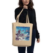 Load image into Gallery viewer, woman modeling/holding oyster colored tote bag, certified organic. Image design: Design: Watercolor raven and roses, with a light blue and white watercolor background and shooting stars print behind the image