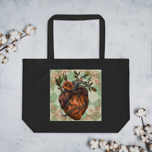 Load image into Gallery viewer, large black tote bag, cotton, certified organic. Image design: Red illustrated heart with vines and rose, wavy green checkered print background behind the image