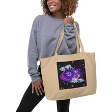 Load image into Gallery viewer, woman holding/modeling large oyster colored tote bag, certified organic, tote bag, dreamy eye with a crescent moon in the iris, surrounded by soft, whimsical clouds, pink and purple stars, orange highlights.