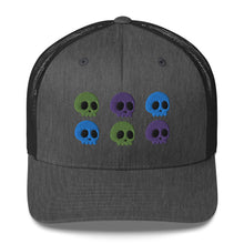 Load image into Gallery viewer, retro trucker hat dark grey heather, with image design of 6 purple, green, and blue skulls, 2 of each color, in two rows. Front view.