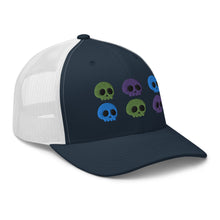 Load image into Gallery viewer, retro trucker hat navy blue white, with image design of 6 purple, green, and blue skulls, 2 of each color, in two rows. side view.