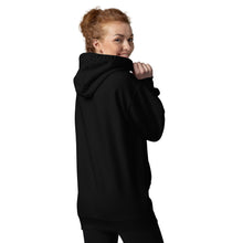 Load image into Gallery viewer, woman modeling/wearing black unisex hoodie, with pockets, with image phrase "Make peace, not war." with image graphic of a skeleton hand holding a daisy flower, and gesturing the peace sign. Front view.