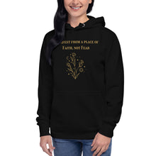 Load image into Gallery viewer, woman modeling/wearing black unisex hoodie, with pockets, with image phrase: "manifest from a place of faith, not fear." with image graphic of flowers, moon, stardust. Front view.