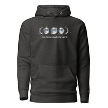 Load image into Gallery viewer, unisex charcoal grey heather hoodie with image phrase "The moon made me do it." With image graphic of watercolor moon phases, decorated with random gold star constellations. Front view.