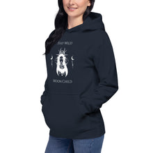 Load image into Gallery viewer, woman modeling/wearing navy blue unisex hoodie, with pockets, with image phrase: "Stay wild, Moon Child." with image of three tribal woman heads, with moon crown, and crescent moons on sides.