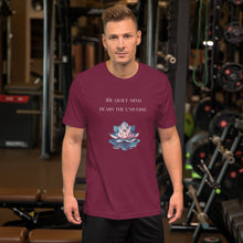 Load image into Gallery viewer, man modeling/wearing unisex maroon t-shirt, with image phrase: "The quiet mind hears the Universe." Image of watercolor pink and blue lotus flower floating on water.