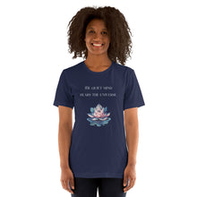 Load image into Gallery viewer, woman modeling/wearing unisex navy blue t-shirt, with image phrase: "The quiet mind hears the Universe." Image of watercolor pink and blue lotus flower floating on water.