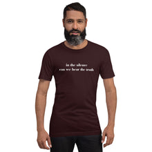 Load image into Gallery viewer, man modeling/wearing unisex oxblood black t-shirt, with image phrase: "in the silence can we hear the truth." Front view.