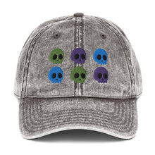 Load image into Gallery viewer, vintage denim cap charcoal grey, with image design of 6 purple, green, and blue skulls, 2 of each color, in two rows. Front view.