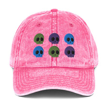 Load image into Gallery viewer, vintage denim cap pink, with image design of 6 purple, green, and blue skulls, 2 of each color, in two rows. Front view.