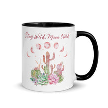 Load image into Gallery viewer, 11 oz. white ceramic coffee/tea mug with solid black handle, rim, and inside. Image Design: Moon phases, colorful pink and green tinged cacti, with "Stay Wild Moon Child" text. Right hand side view.