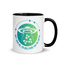 Load image into Gallery viewer, 11 oz. white ceramic coffee/tea mug with solid black handle, rim, and inside. Image Design: ufo ship abducting/beaming up coffee beans. background blue to light green gradient, stars. Text under image: "Don't mind me, I'm only here for the Coffee." right hand side view.