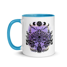 Load image into Gallery viewer, 11 oz. white ceramic coffee/tea mug with solid light blue handle, rim, and inside. Design: Moth with a skull, moon phases, pentacle, mushrooms, and a crystal vial. left hand side view.