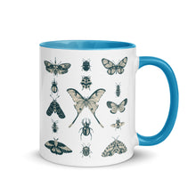 Load image into Gallery viewer, 11 oz. white ceramic coffee/tea mug with solid light blue handle, rim, and inside. Image Design: vintage beige and blue print images of various moths, butterflies, and beetles, all arranged in rows and columns. Right hand side view. Halloween, spooky season.