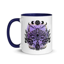 Load image into Gallery viewer, 11 oz. white ceramic coffee/tea mug with solid navy blue handle, rim, and inside. Design: Moth with a skull, moon phases, pentacle, mushrooms, and a crystal vial. left hand side view.