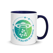 Load image into Gallery viewer, 11 oz. white ceramic coffee/tea mug with solid navy blue handle, rim, and inside. Image Design: ufo ship abducting/beaming up coffee beans. background blue to light green gradient, stars. Text under image: "Don't mind me, I'm only here for the Coffee." right hand side view.