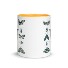 Load image into Gallery viewer, 11 oz. white ceramic coffee/tea mug with solid golden yellow handle, rim, and inside. Image Design: vintage beige and blue print images of various moths, butterflies, and beetles, all arranged in rows and columns. Center front view. Halloween, spooky season.
