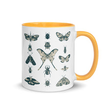 Load image into Gallery viewer, 11 oz. white ceramic coffee/tea mug with solid golden yellow handle, rim, and inside. Image Design: vintage beige and blue print images of various moths, butterflies, and beetles, all arranged in rows and columns. Right hand side view. Halloween, spooky season.