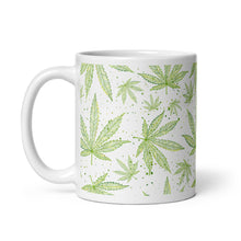 Load image into Gallery viewer, 11 oz. White glossy ceramic coffee/tea mug. Image Design: Green marijuana leaves with gold edges and classy dots, wrapped around print. Left hand side view.