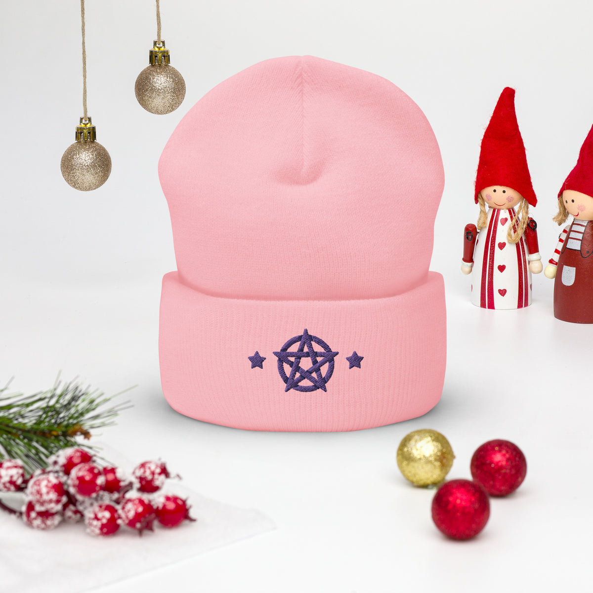 cuffed beanie baby pink, with image design of purple pentacle and stars. background: winter themed, Christmas gifts.
