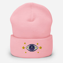 Load image into Gallery viewer, cuffed beanie baby pink, with image design of purple eye of protection/evil eye, with yellow stars. background: winter themed, Christmas gifts.
