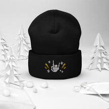 Load image into Gallery viewer, cuffed beanie black, with image design of rock on skeleton hand, pentagram stars, lightning symbols. background: winter themed, Christmas gifts.
