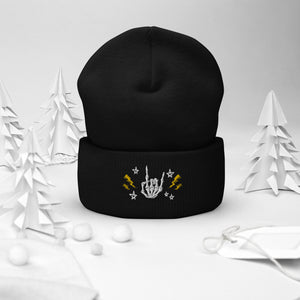 cuffed beanie black, with image design of rock on skeleton hand, pentagram stars, lightning symbols. background: winter themed, Christmas gifts.