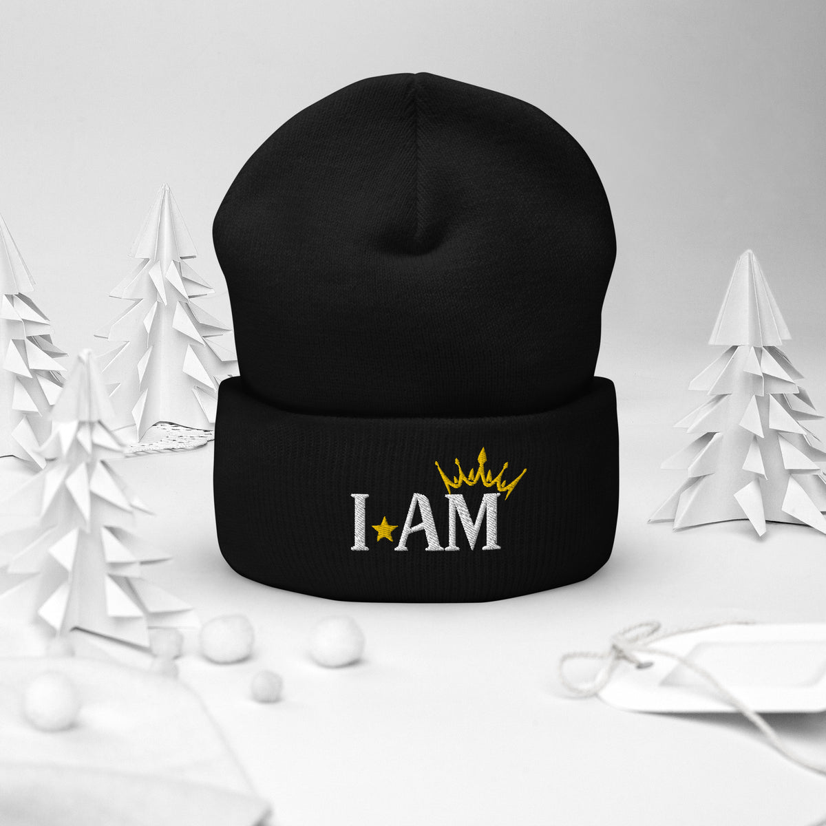 cuffed beanie black, with image phrase "I AM," with image of a crown over the word AM. background: winter themed, Christmas gifts.
