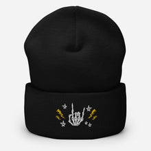 Load image into Gallery viewer, cuffed beanie black, with image design of rock on skeleton hand, pentagram stars, lightning symbols. background: winter themed, Christmas gifts.
