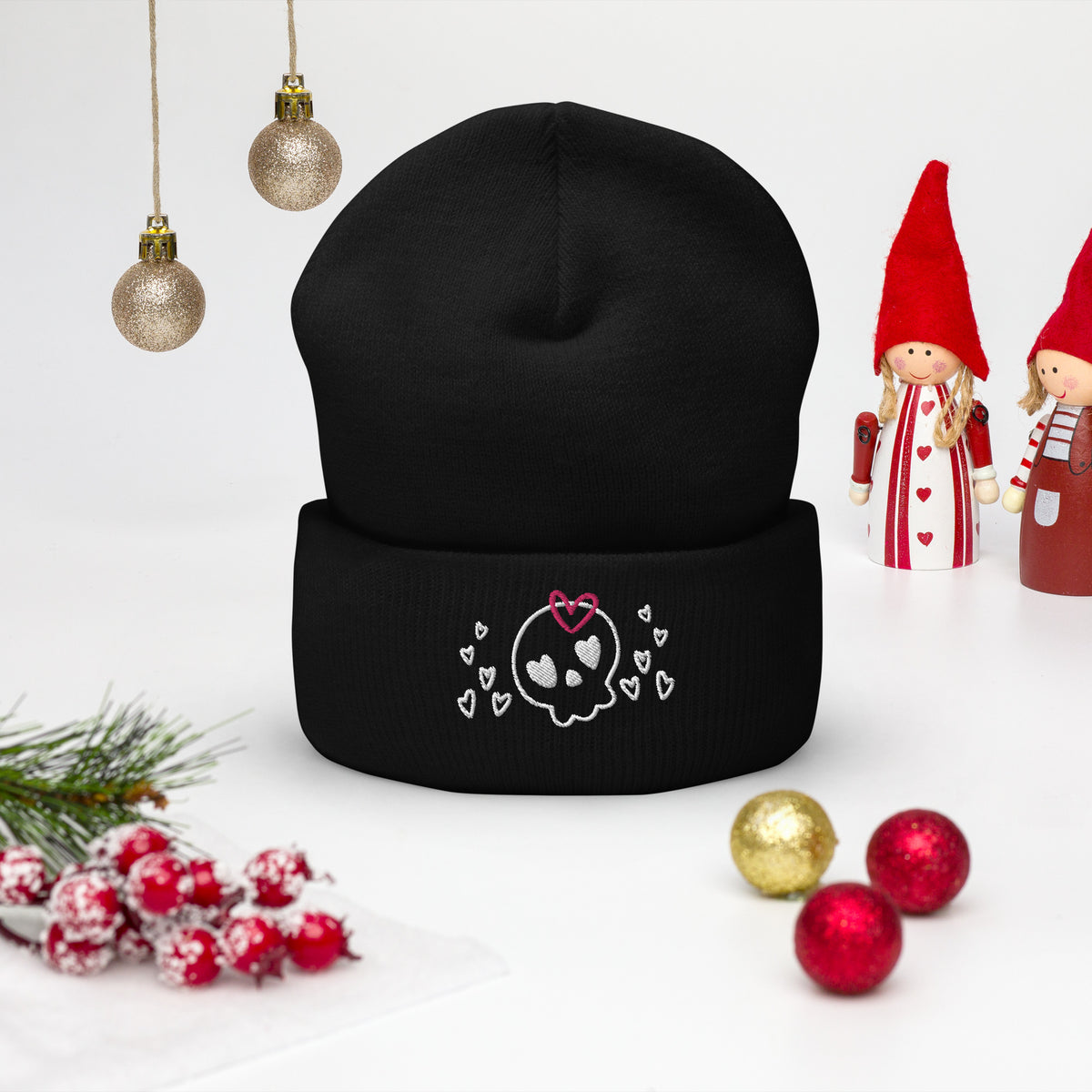 beanie black , with image design of a cartoonish cute skull with heart eyes, a heart bow, and stars. Front view.