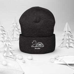 beanie dark grey, with image design of an eye in a cloud, with moon crescent and stars, with the word "Breathe" underneath the image. Front view.