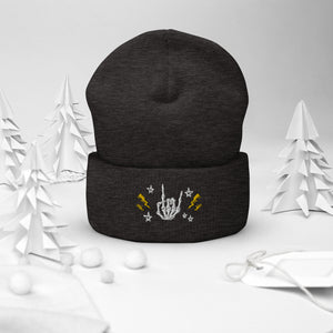 cuffed beanie dark grey, with image design of rock on skeleton hand, pentagram stars, lightning symbols. background: winter themed, Christmas gifts.