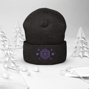 cuffed beanie dark grey, with image design of purple third eye chakra symbol, with purple stars. background: winter themed, Christmas gifts.