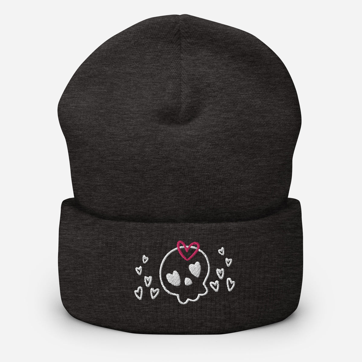 beanie dark grey, with image design of a cartoonish cute skull with heart eyes, a heart bow, and stars. Front view.