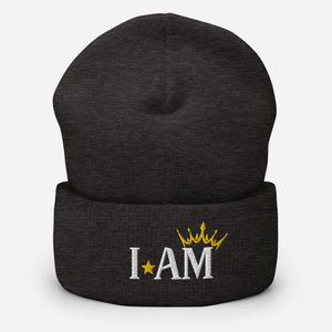 cuffed beanie dark grey, with image phrase "I AM," with image of a crown over the word AM. background: winter themed, Christmas gifts.