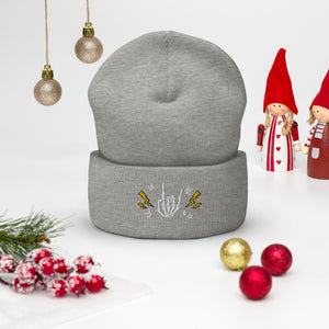 cuffed beanie heather grey, with image design of rock on skeleton hand, pentagram stars, lightning symbols. background: winter themed, Christmas gifts.