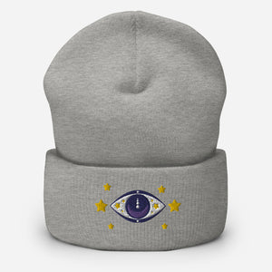 cuffed beanie heather grey, with image design of purple eye of protection/evil eye, with yellow stars. background: winter themed, Christmas gifts.