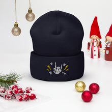 Load image into Gallery viewer, cuffed beanie navy blue, with image design of rock on skeleton hand, pentagram stars, lightning symbols. background: winter themed, Christmas gifts.
