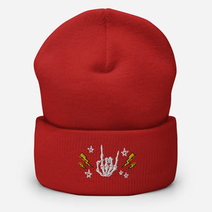 cuffed beanie red, with image design of rock on skeleton hand, pentagram stars, lightning symbols. background: winter themed, Christmas gifts.