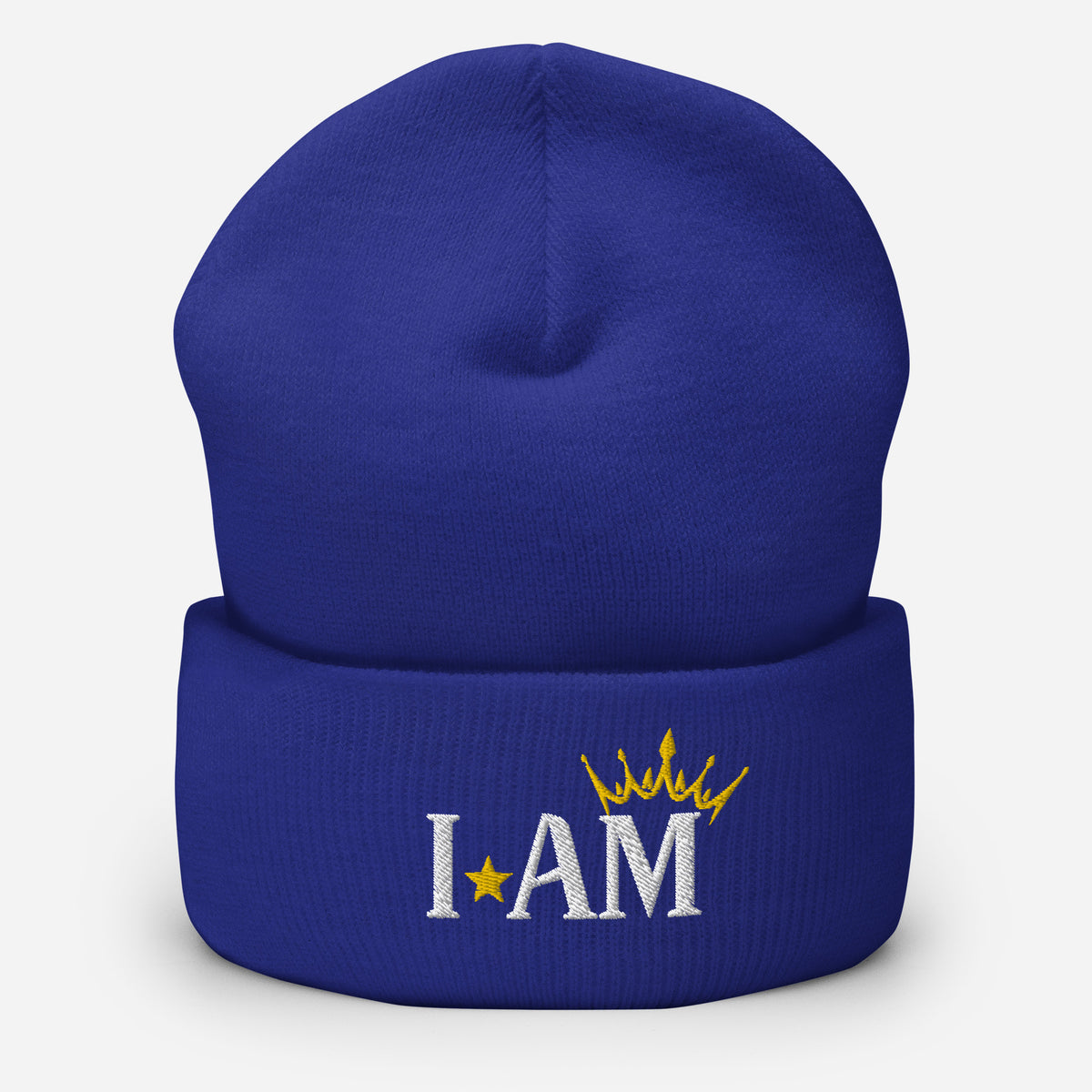 cuffed beanie royal blue, with image phrase "I AM," with image of a crown over the word AM. background: winter themed, Christmas gifts.
