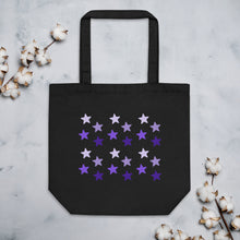 Load image into Gallery viewer, black tote bag, certified organic, cotton, features rows of purple stars, with each row darker than the one above it, creating a striking gradient effect. 4 shades of purple. 
