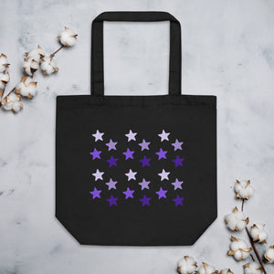 black tote bag, certified organic, cotton, features rows of purple stars, with each row darker than the one above it, creating a striking gradient effect. 4 shades of purple. 