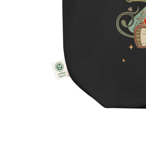 close up image of tag showing certified organic, black tote bag, with Image Design: Old book, vial, mushroom, and butterfly with a vintage look