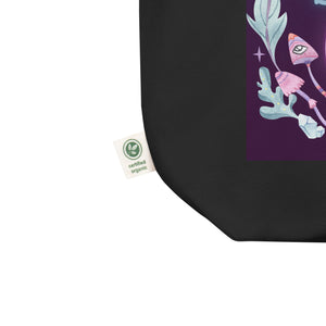 black tote bag, with close up picture of tag, showing as certified organic, tote bag. Image design: whimsical mushrooms with eyes, crystals, with text, "Go smudge yourself."