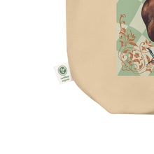 Load image into Gallery viewer, close up of tag, showing certified organic, oyster colored tote bag, certified organic. Image design: Red illustrated heart with vines and rose, wavy green checkered print background  behind the image
